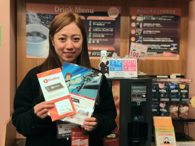 アルバイトスタッフが商品や案内用POPを持って正面を向いている写真