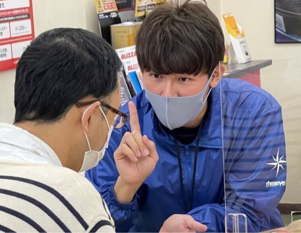 男性スタッフがお客様に案内をしている様子